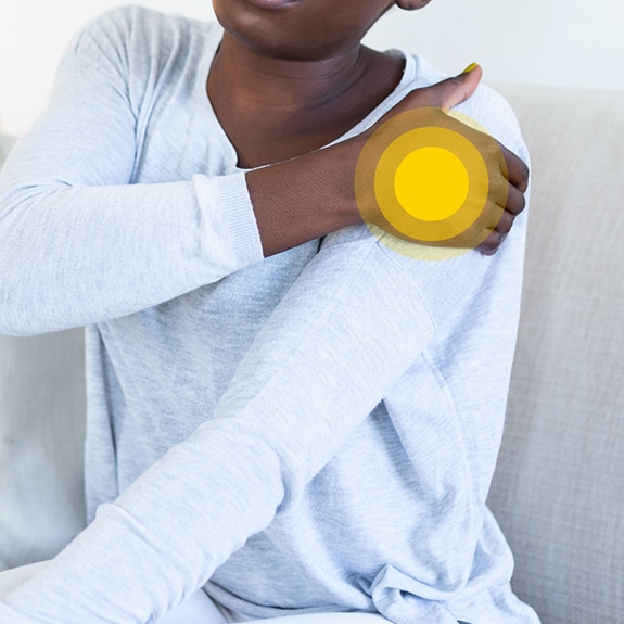 Person with shoulder pain and yellow circle on shoulder