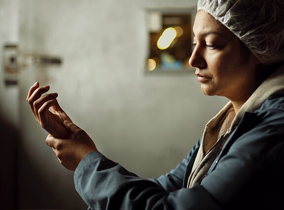 Person at work in hair net rubbing wrist