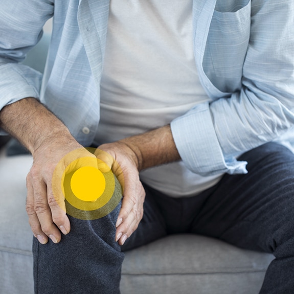 Person sitting with yellow circle on knee