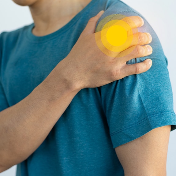 Person with shoulder pain and yellow circle on shoulder