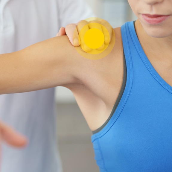 Person with shoulder pain and yellow circle on shoulder