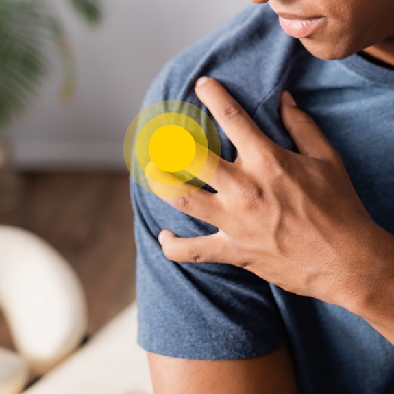 Person with shoulder pain and yellow circle on shoulder